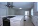 Bright kitchen features white cabinets, quartz countertops and large center island with cooktop at 746 N Halifax Ave, Daytona Beach, FL 32118