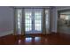 Living room featuring hardwood floors and a view of the kitchen through the French doors at 746 N Halifax Ave, Daytona Beach, FL 32118