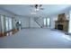 Spacious living room with stone fireplace, staircase, carpet, and French door access to the exterior at 746 N Halifax Ave, Daytona Beach, FL 32118