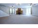 Spacious living room featuring a stone fireplace, carpet, and ample natural light at 746 N Halifax Ave, Daytona Beach, FL 32118