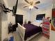 Bedroom with ceiling fan, a white bed with purple sheets and a colorful dresser at 812 Marion St, Daytona Beach, FL 32114