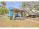 A bright blue home with orange accents, featuring a cozy front porch, and a well maintained yard at 812 Marion St, Daytona Beach, FL 32114