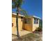 Exterior view of the bright yellow home surrounded by a palm tree and blue skies at 835 E 24Th Ave # 111, New Smyrna Beach, FL 32169