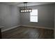 This dining room features light gray walls, wood-look floors, white trim, and a modern linear chandelier over the dining area at 855 Sugar House Dr, Port Orange, FL 32129