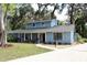 Charming two-story home with blue siding, red front door, and mature landscaping in a lush, shady neighborhood at 855 Sugar House Dr, Port Orange, FL 32129
