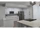 Modern kitchen features white cabinets, stainless steel appliances, a gray backsplash, and an island with cooktop at 855 Sugar House Dr, Port Orange, FL 32129