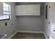 Spacious laundry room offering white cabinets, wood-look flooring, a window and white trim at 855 Sugar House Dr, Port Orange, FL 32129