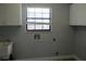 Bright laundry room with white cabinets, utility sink, and a window at 855 Sugar House Dr, Port Orange, FL 32129