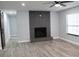 Bright living room with gray tile fireplace, modern ceiling fan, and wood-look flooring at 855 Sugar House Dr, Port Orange, FL 32129
