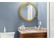 Charming bathroom features a unique porthole mirror and granite vanity at 898 Baybreeze Way # 880, New Smyrna Beach, FL 32169