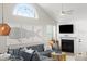 Bright living area with vaulted ceilings, coastal art, a gray sectional, and a fireplace for relaxation and enjoyment at 898 Baybreeze Way # 880, New Smyrna Beach, FL 32169