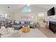 Well-lit living room with vaulted ceilings, art, a gray sectional, and a fireplace for cozy living and entertaining at 898 Baybreeze Way # 880, New Smyrna Beach, FL 32169