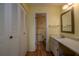 Bright bathroom with a single sink vanity, louvred closet and wood-look floors at 112 Lagoon Ct, New Smyrna Beach, FL 32169