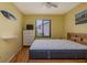 Bedroom featuring hardwood floors, window, dresser, and surf themed decor at 112 Lagoon Ct, New Smyrna Beach, FL 32169