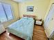 Bright bedroom with yellow walls, wood headboard, and plenty of natural light from the window at 112 Lagoon Ct, New Smyrna Beach, FL 32169