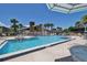 Community pool surrounded by lush palms with a 6 ft depth, perfect for relaxing on sunny days at 112 Lagoon Ct, New Smyrna Beach, FL 32169
