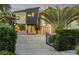 Modern home with unique architectural details, including a gated entrance and lush landscaping at 208 Dune Cir, New Smyrna Beach, FL 32169
