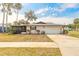 Home's exterior view includes the garage, screened-in porch, and lush landscaping at 222 Brittany Ave, Port Orange, FL 32127