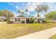 Charming single-story home with a well-manicured lawn, mature trees, and inviting front entrance at 222 Brittany Ave, Port Orange, FL 32127