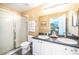Bright bathroom featuring double sinks with white cabinets, shower, toilet, and large mirror at 2689 Sicily Dr, New Smyrna Beach, FL 32168