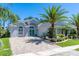 Attractive home showcasing a charming front exterior with lush landscaping and a paver driveway at 3045 Borassus Dr, New Smyrna Beach, FL 32168