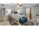 Cozy bedroom with a decorative ceiling fan, stylish furnishings, and blue decorative pillows and bench at 312 Jefferson Ave, Port Orange, FL 32127