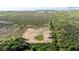 Overhead view of rural land near a lake and marshland, featuring sparse greenery and a small structure at 3890 Skyway Dr, Sanford, FL 32773