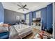 Bedroom featuring blue walls, a ceiling fan, a large window, and ample display shelving at 465 White Cotton Cir, Oviedo, FL 32765