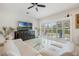 Bright living room with a curved sofa and a TV; with sliding doors at 465 White Cotton Cir, Oviedo, FL 32765