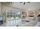 Bright living room featuring tile floors and a view of the large screened-in patio through shuttered doors at 465 White Cotton Cir, Oviedo, FL 32765