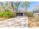 View of the home showcasing the driveway and natural landscape surrounding it at 6205 Klondike Dr, Port Orange, FL 32127