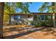 Cozy one-story home features a neutral exterior with mature trees and shrubs in the front yard at 68 Crooked Pine Rd, Port Orange, FL 32128