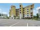 Bright yellow condominium building featuring covered balconies and parking in the front at 7 Riverwalk Dr # 206, New Smyrna Beach, FL 32169