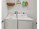 Laundry room with a white washer and dryer set, white wire shelving, and white walls at 7 Riverwalk Dr # 206, New Smyrna Beach, FL 32169