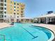 Stunning community pool area showcasing a sparkling pool, comfortable seating, and the condo building in the background at 7 Riverwalk Dr # 206, New Smyrna Beach, FL 32169