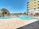 Inviting community pool area with palm trees, comfortable seating, and a view of the adjacent buildings at 7 Riverwalk Dr # 206, New Smyrna Beach, FL 32169