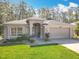 Charming single-story home featuring a well-manicured lawn and two-car garage at 1077 Crystal Creek Dr, Port Orange, FL 32128