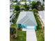 Aerial view of a bright blue house with a well-manicured lawn and a waterway nearby at 113 Douglas St, Edgewater, FL 32141