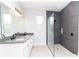 Stylish bathroom features a tiled shower with glass partition and a double sink vanity with dark countertops at 113 Douglas St, Edgewater, FL 32141