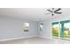 Spacious living room featuring a fan, windows for natural light, and a glass sliding door at 113 Douglas St, Edgewater, FL 32141