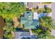 Aerial view of home with green roof, surrounding lush landscaping, mature trees, and swimming pool at 1227 Wayne Ave, New Smyrna Beach, FL 32168