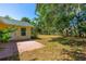 View of back of home featuring the grass backyard, patio, and mature trees at 1227 Wayne Ave, New Smyrna Beach, FL 32168