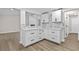 Kitchen area featuring white cabinets, stone backsplash, and a convenient view of the living room at 1227 Wayne Ave, New Smyrna Beach, FL 32168