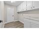 Bright laundry room boasts ample storage with upper cabinets, plus marbled countertop and wood-look floors at 1227 Wayne Ave, New Smyrna Beach, FL 32168