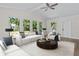 A spacious living room is decorated with neutral furniture and filled with light from the many large windows at 1227 Wayne Ave, New Smyrna Beach, FL 32168