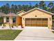 Charming yellow home featuring a well-manicured lawn, lovely landscaping and an inviting entrance at 1827 Palmetto Scrub Cir, Port Orange, FL 32128