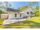 Home featuring a patio, balcony, and ample windows, surrounded by a lush lawn and mature trees at 1910 Botree Ct, Port Orange, FL 32128