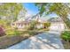 Charming home with a sprawling front porch, large driveway, and well-manicured lawn and mature trees at 1910 Botree Ct, Port Orange, FL 32128