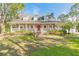 Inviting home featuring a classic front porch, a vibrant red front door, and a lush green lawn at 1910 Botree Ct, Port Orange, FL 32128