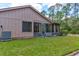 Rear view of the home featuring the screened in patio and the green backyard at 1928 Sprucewood Way # 58, Port Orange, FL 32128